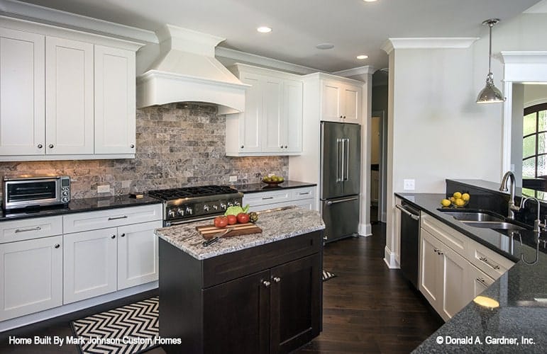 The hallway next to the two-door fridge leads to the family bedrooms and the angled garage.