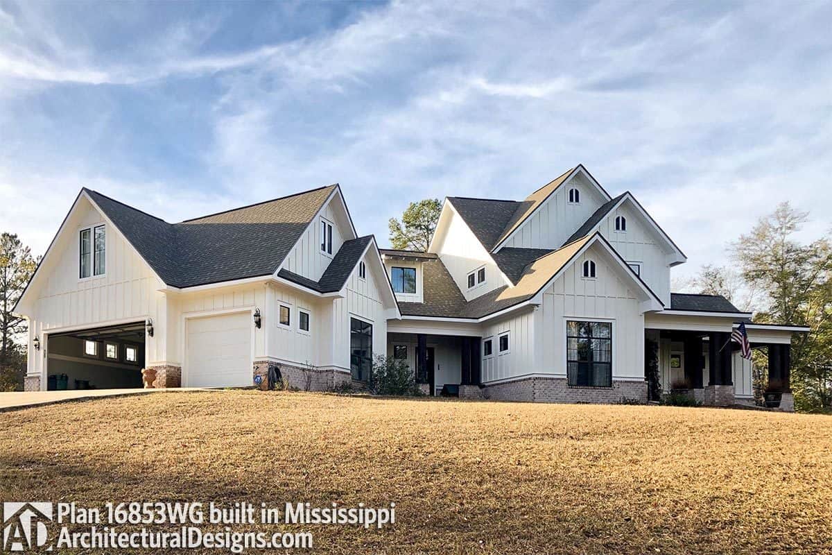 This home has board and batten siding, tiled gable roofs, and a side-entry garage.