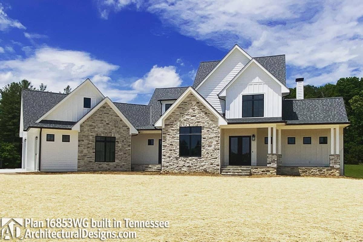 A combination of stone and vertical lap siding embellish this two-story farmhouse.