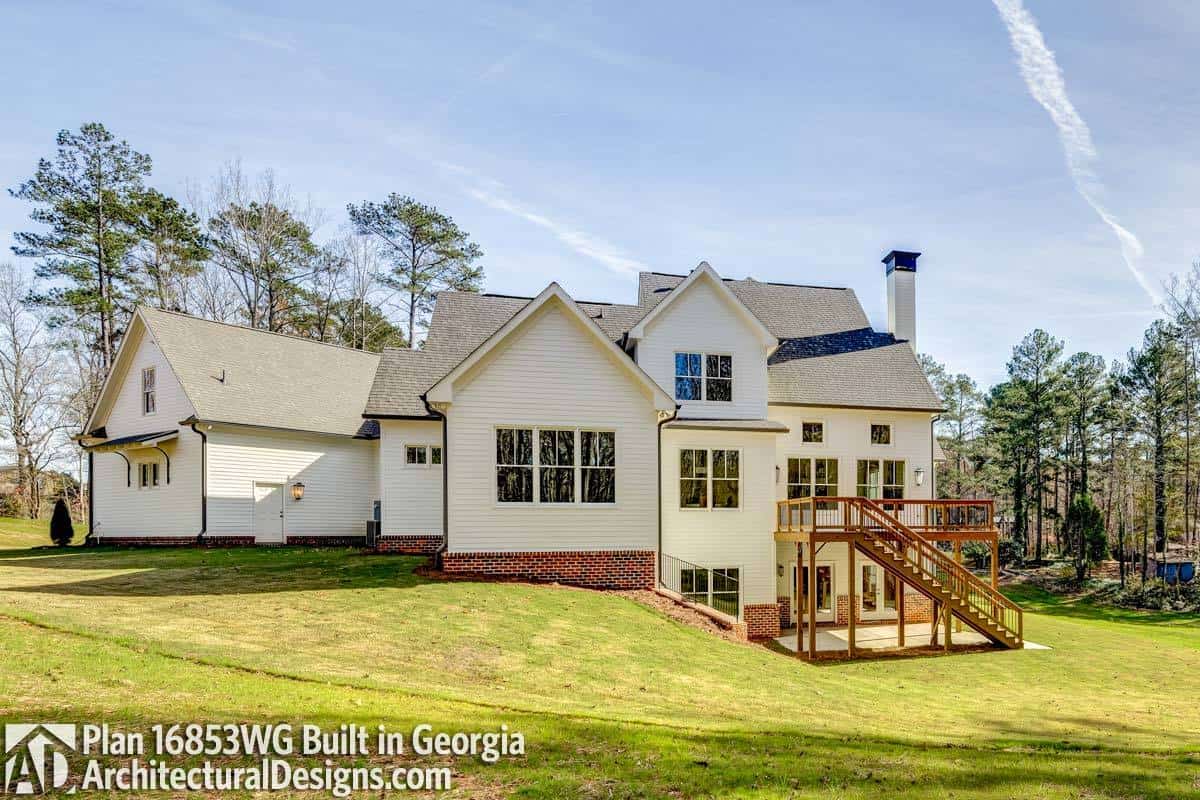 Rear exterior view showing the gable rooflines, tinted glass windows, and a spacious deck supported by slim columns.