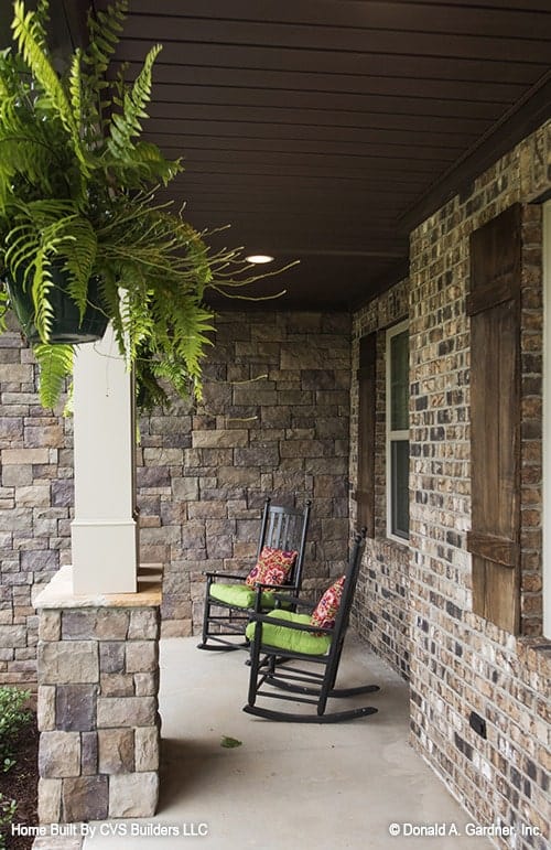 Inviting Porch with Stone Columns and Green Accents