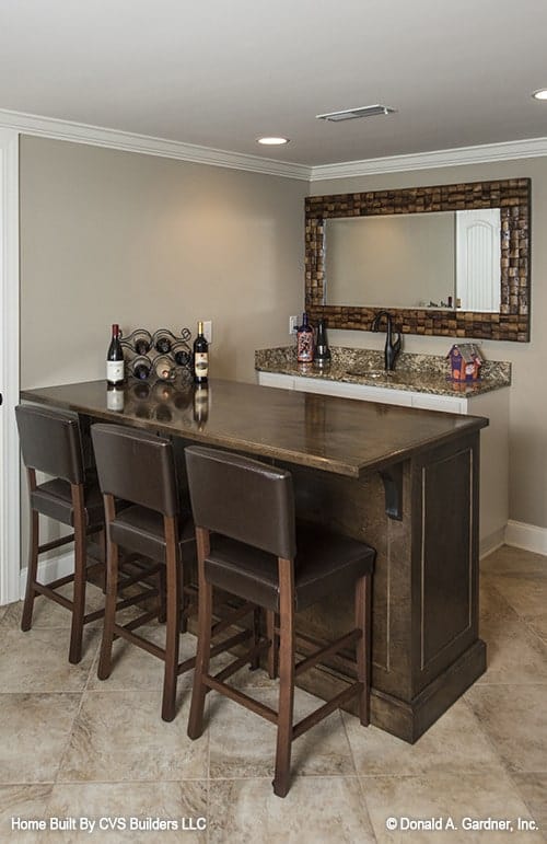 Sleek Basement Bar with Wooden Accents and Mosaic Mirror