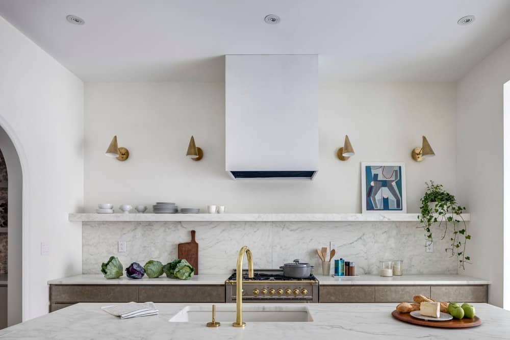 The kitchen has a consistent light beige tone with open shelves and a large kitchen island of the same light beige tone.