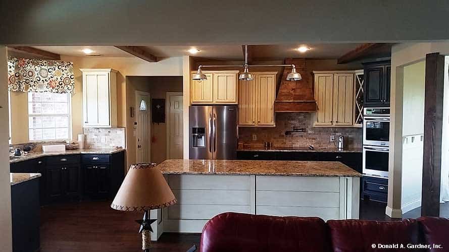 Kitchen with custom cabinets, granite countertops, stainless steel appliances, and a large center island.