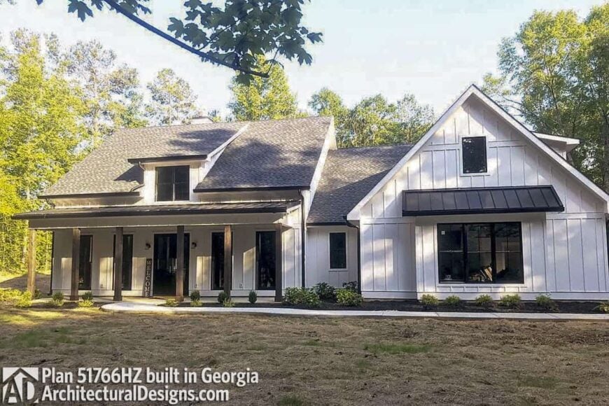 This home has a vertical lap siding, metal awnings, and dark wood pillars framing the front porch.