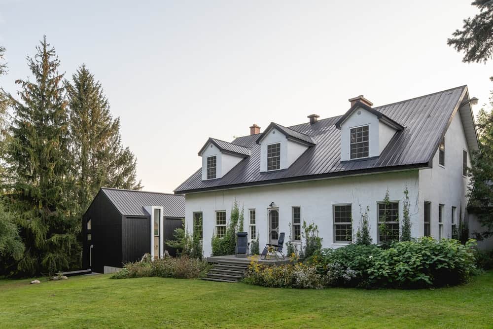 This is a look at the front of the house with a traditional style that contrasts the dark and minimalist extension structure on the side.