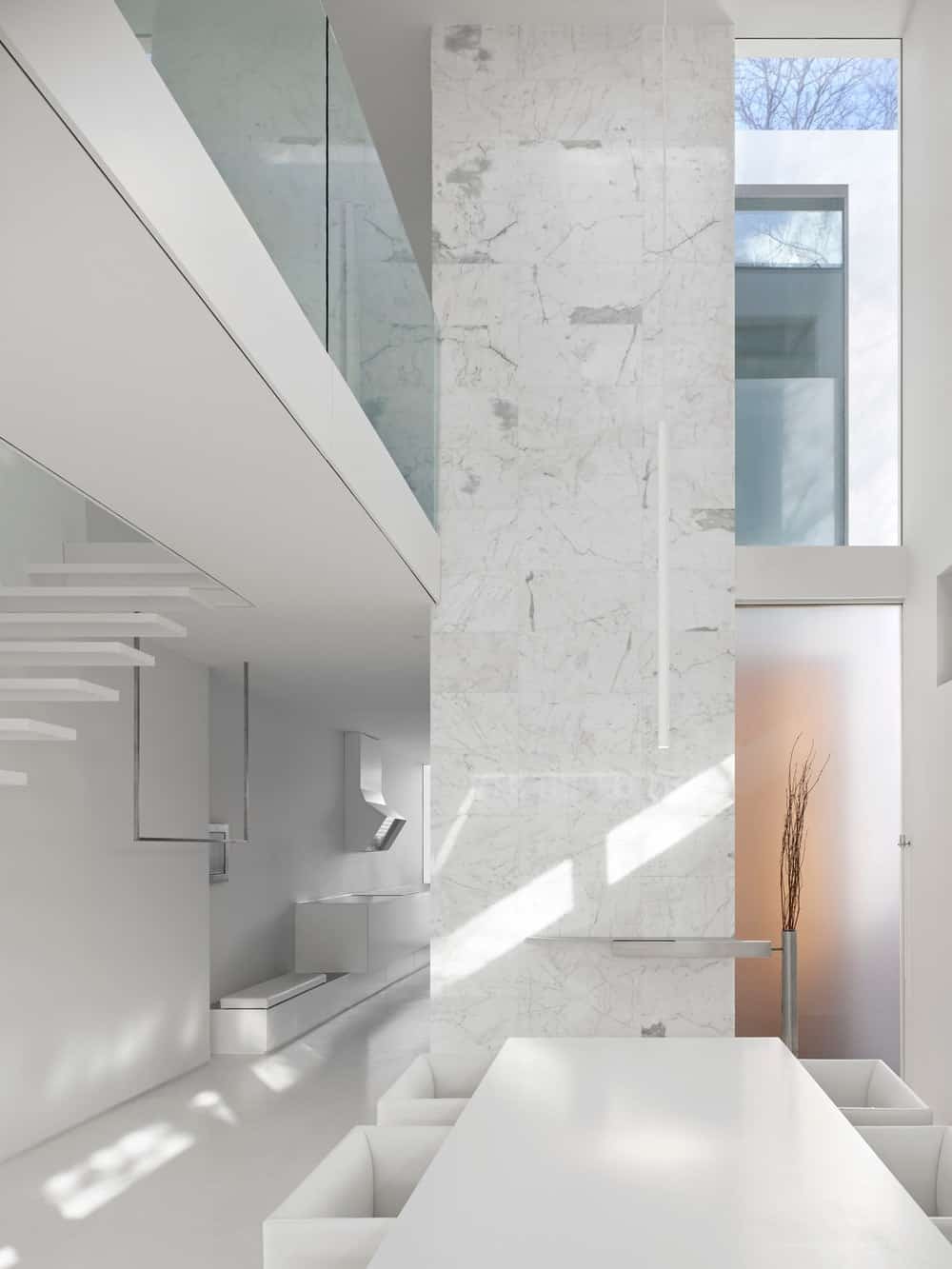 This other view of the dining set shows the other side with a tall marble wall and a glimpse of the kitchen on the far side.