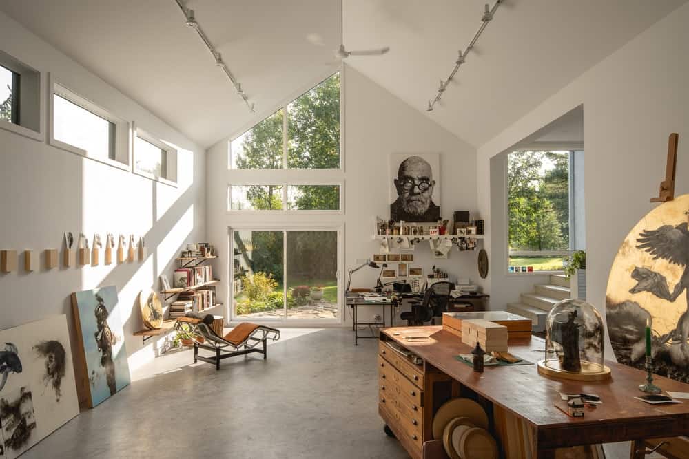 This is the spacious and airy interiors of the art studio with a tall cathedral ceiling and white walls.