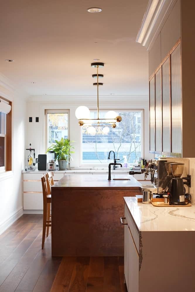 This is a view of the kicthen with a wood-toned kitchen island that matches with the hardwood flooring.