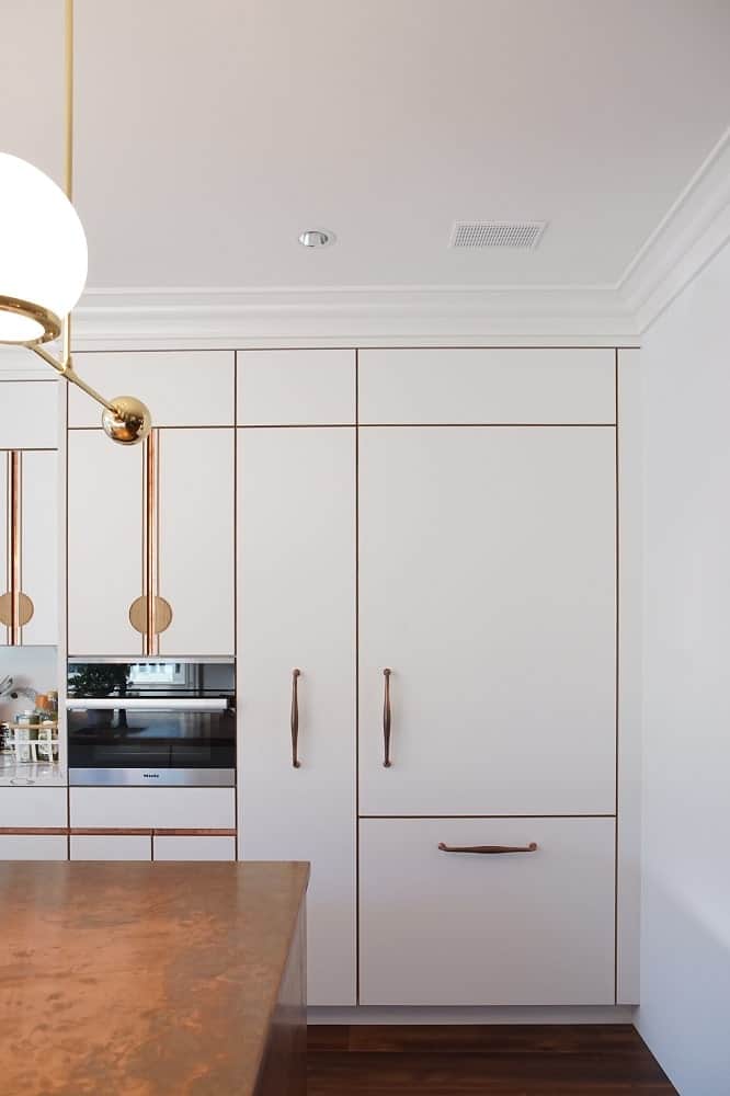 This is a view of the built-in cabinetry from the vantage of the kitchen island showcasing the appliances and the fridge that blends with the cabinetry.