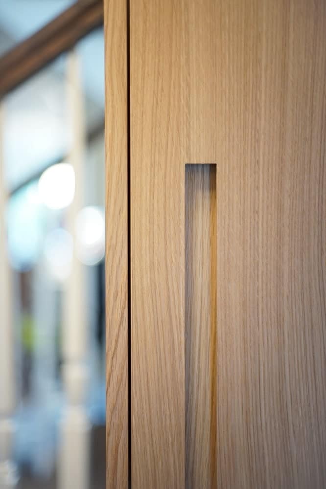 This is a close look at the masterful craftsmanship of the handle of the wooden cabinetry in the dining area.