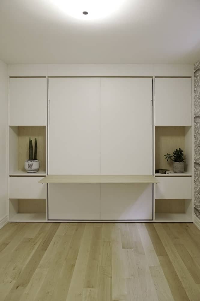 This gray bed is a Murphy bed that can be tucked into the wall and the bedroom becomes a large open area.