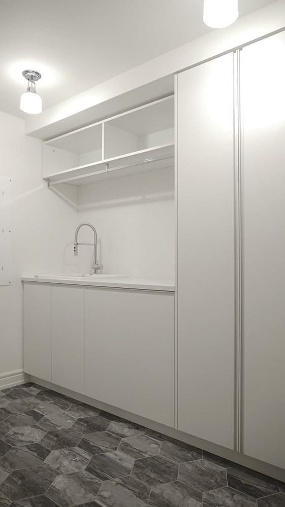 On the other side of the embedded machines is a small sink area with shelves above and cabinets on the side.