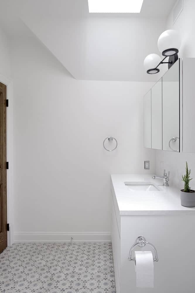 This is the white vanity of the bathroom topped with mirrors and lights.