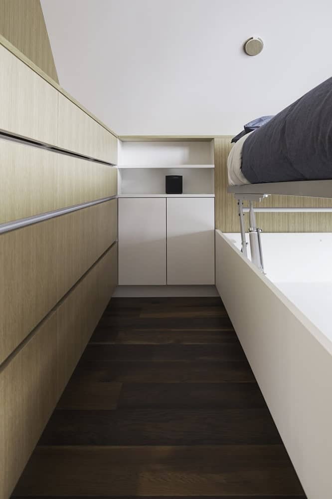 This is a close look at the bedroom that showcases its abundance of storage with built-in cabinets and a bed that has storage underneath.