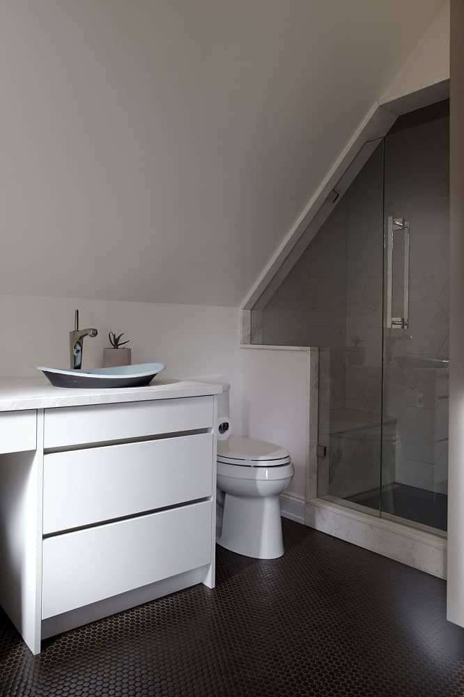 The vanity has a freestanding sink on the side above the drawers.