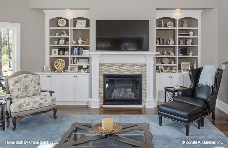 White built-ins flank the fireplace that's topped with a wall-mounted TV.