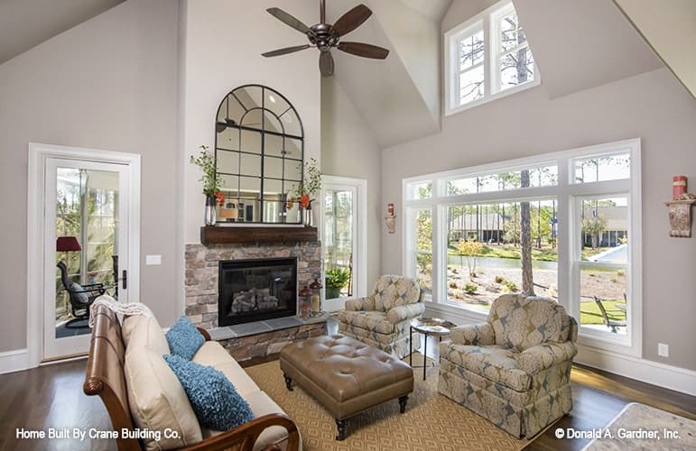 The family room has cozy seats, a fireplace, and a high cathedral ceiling.