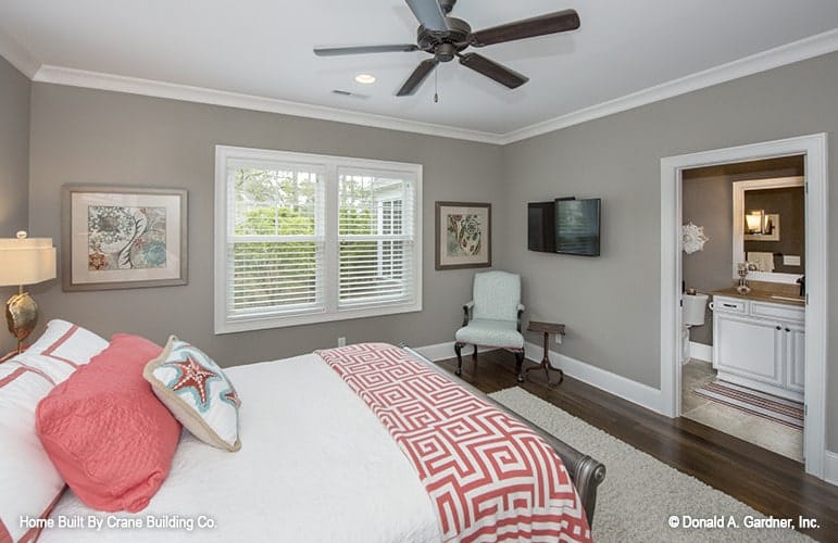 This bedroom has a wooden bed, a small sitting area, and a private bathroom.