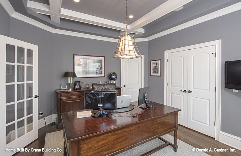 Study with special ceiling treatment, wooden furnishings, and gray walls accented with white trims and doors.