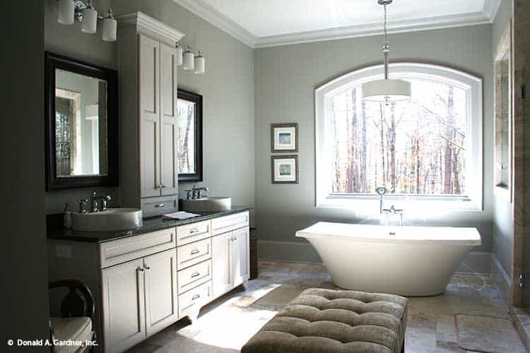 Bright Bathroom with Freestanding Tub Under Arched Window