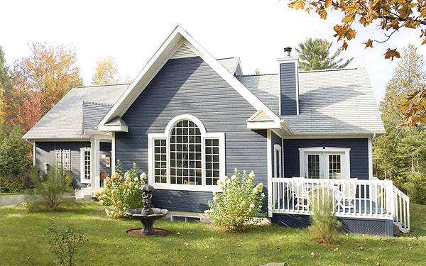 Rear exterior view with palladian window, blue chimney, and a deck framed with white railings.