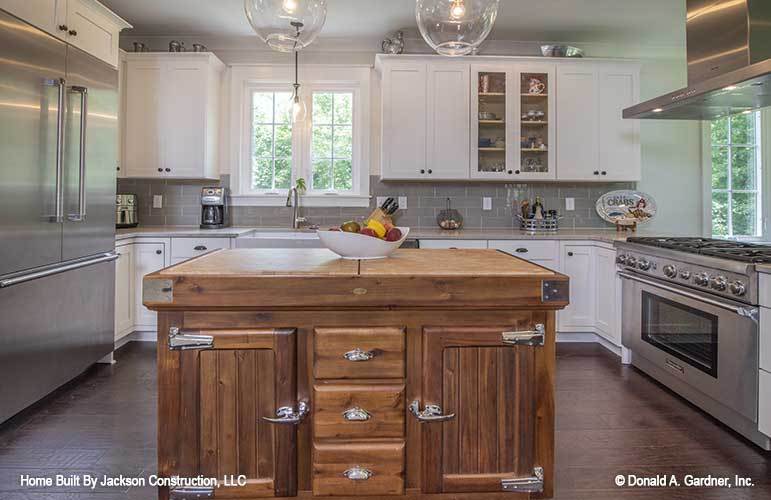 Gray subway tile backsplash and white framed windows complete the kitchen.