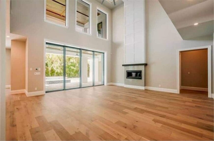 Spacious living room with a two-story ceiling, clerestory windows, and a fireplace.