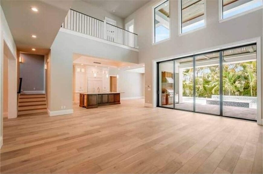 The living room has a great view of the kitchen and second-floor balcony. It extends to the covered lanai via the sliding glass doors.