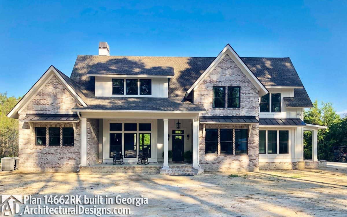 A mixture of vertical lap siding and brick exterior embellish this modern farmhouse.