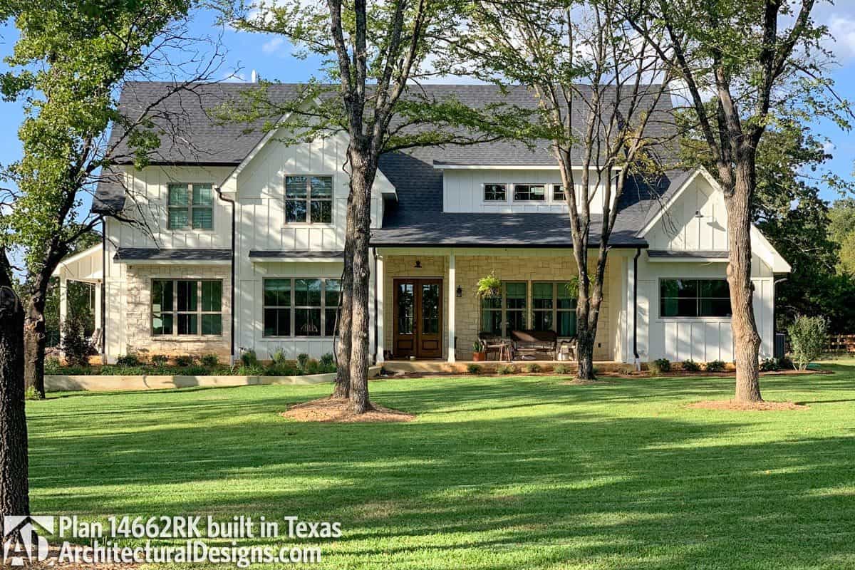 Front exterior view showing the stone accents, board and batten siding, and a wooden french entry door.