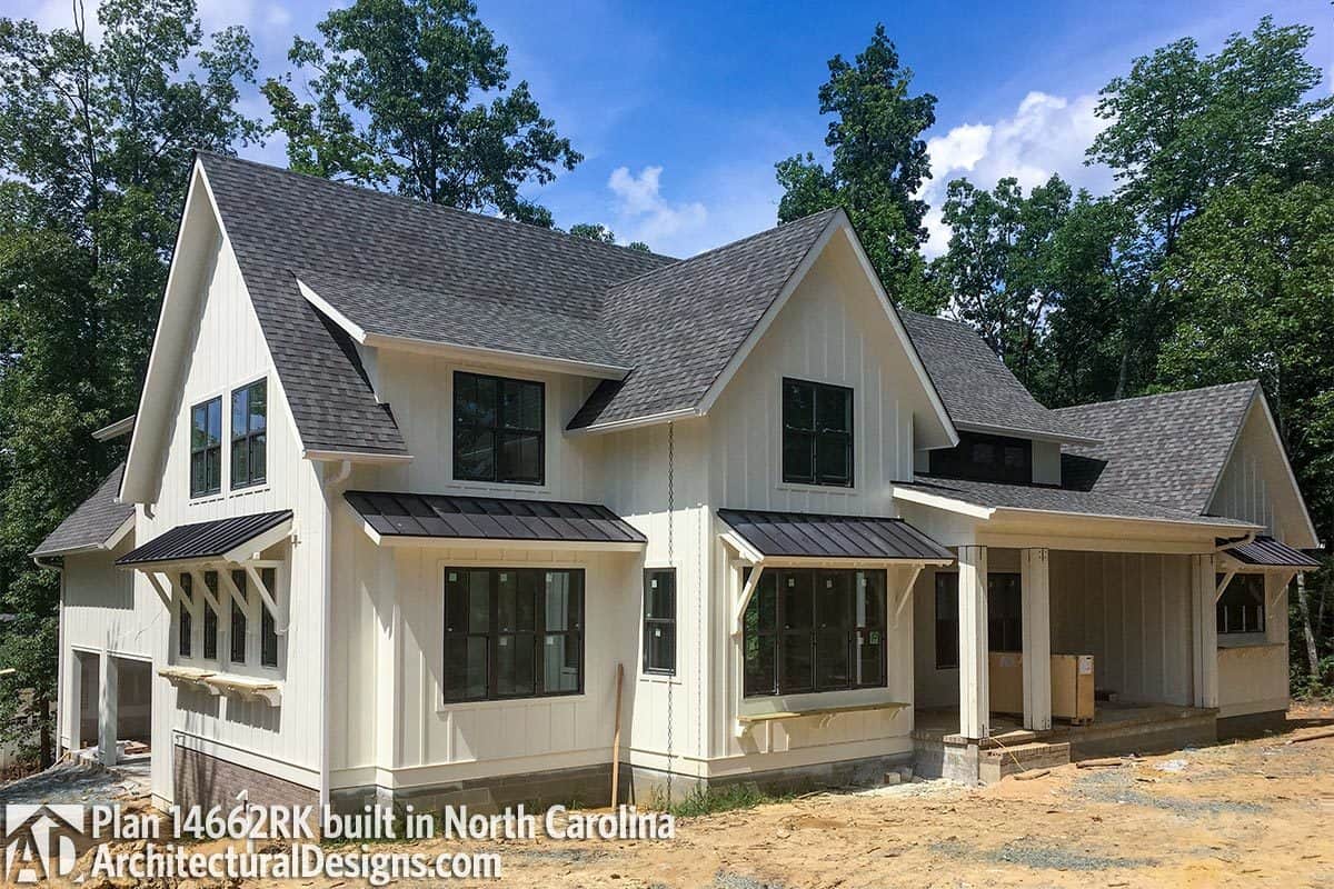 Angled side view showing the covered front porch and the side entry garage topped with tiled roofs.