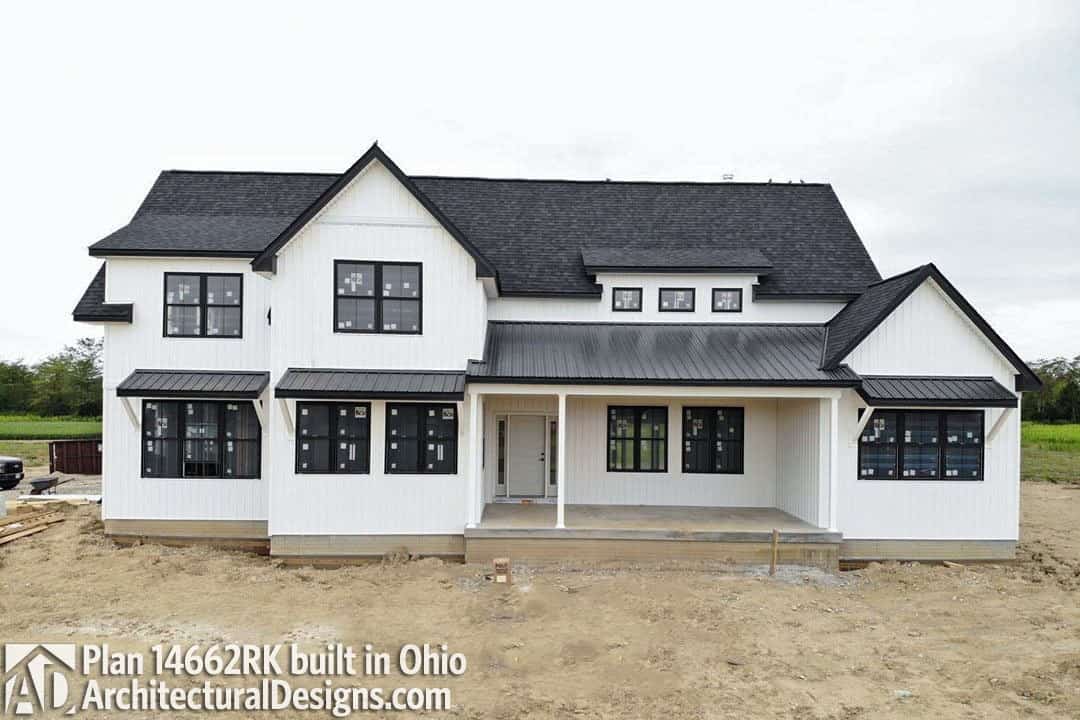 Alternate exterior with stark white siding, concrete bases, and metal awnings.