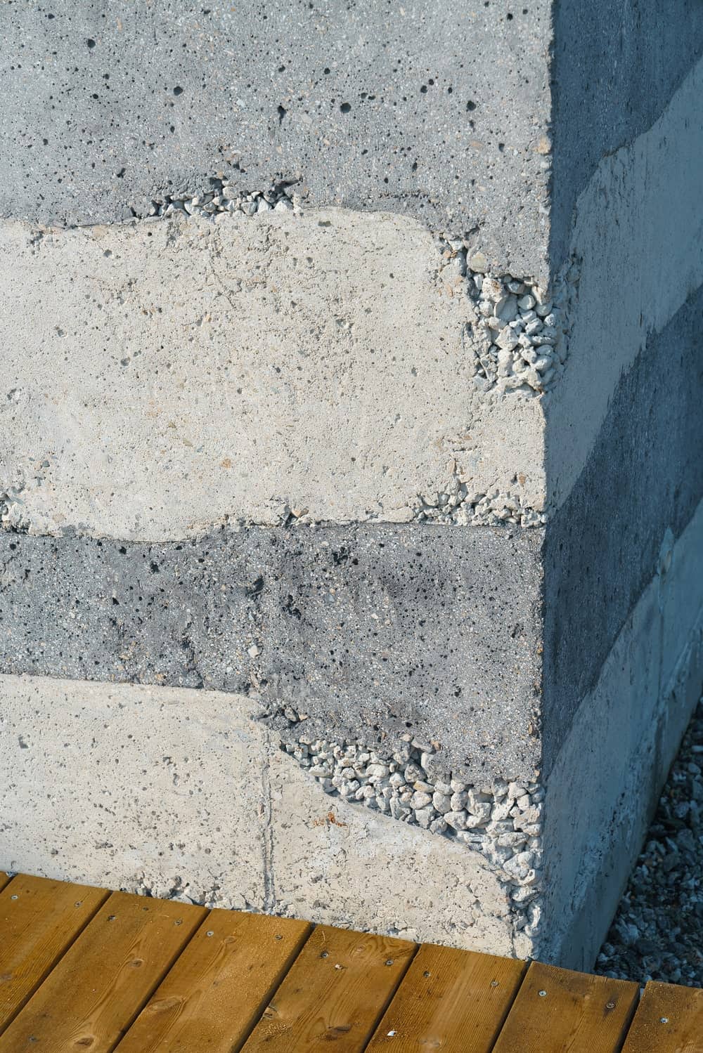 This is a close look at the striped exterior wall of the house and how it is complemented by the wooden walkway.