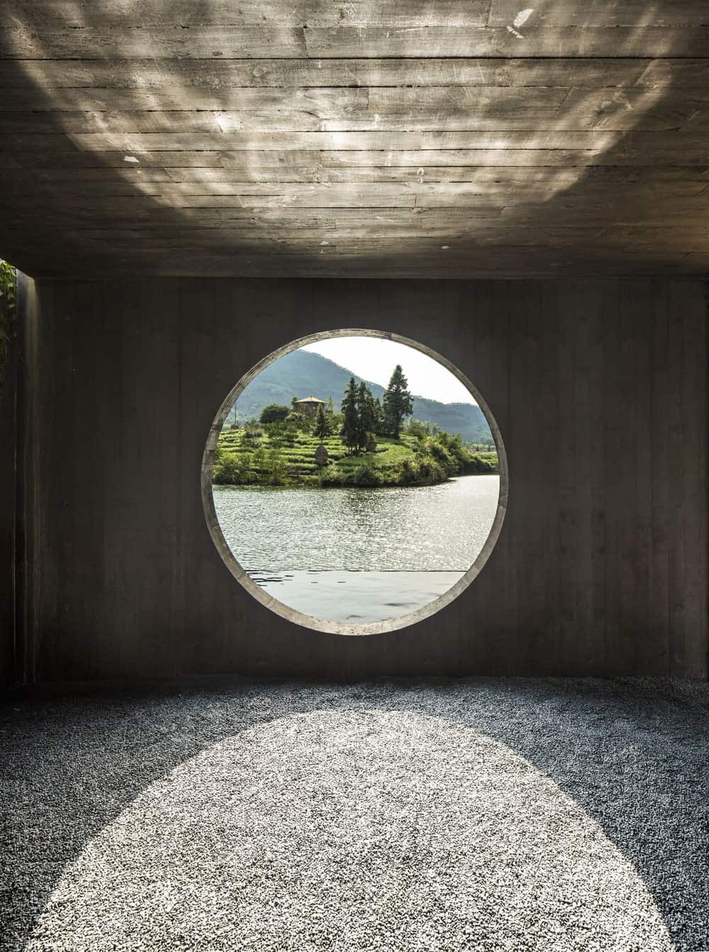 This is an area of the teahouse with a round window overlooking the water scenery and has a graveled flooring.