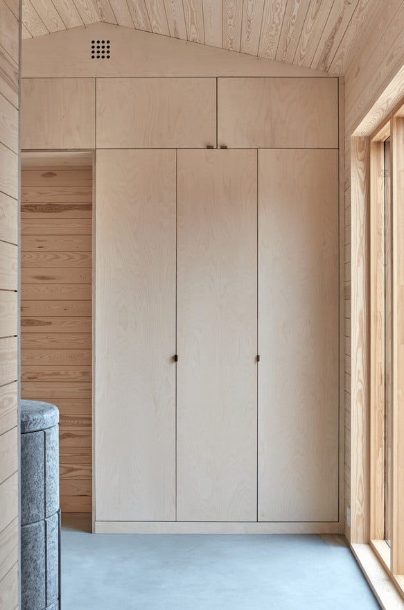 This is a close look at the corner of the house that has built-in cabinets making it stand out against the shiplap walls with its simple design.