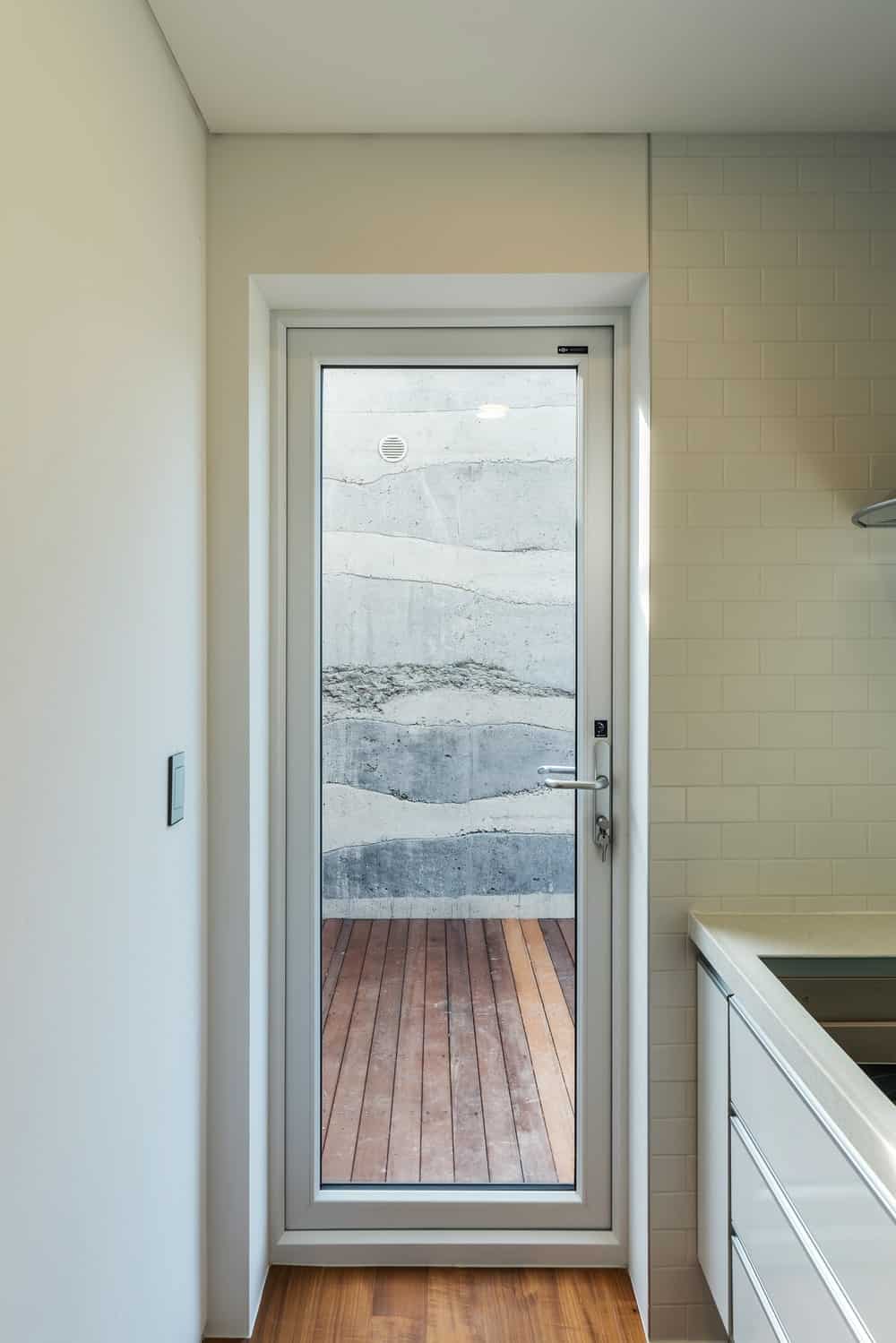 This is a close look at the glass door of the kitchen that leads to a wooden walkway outside.