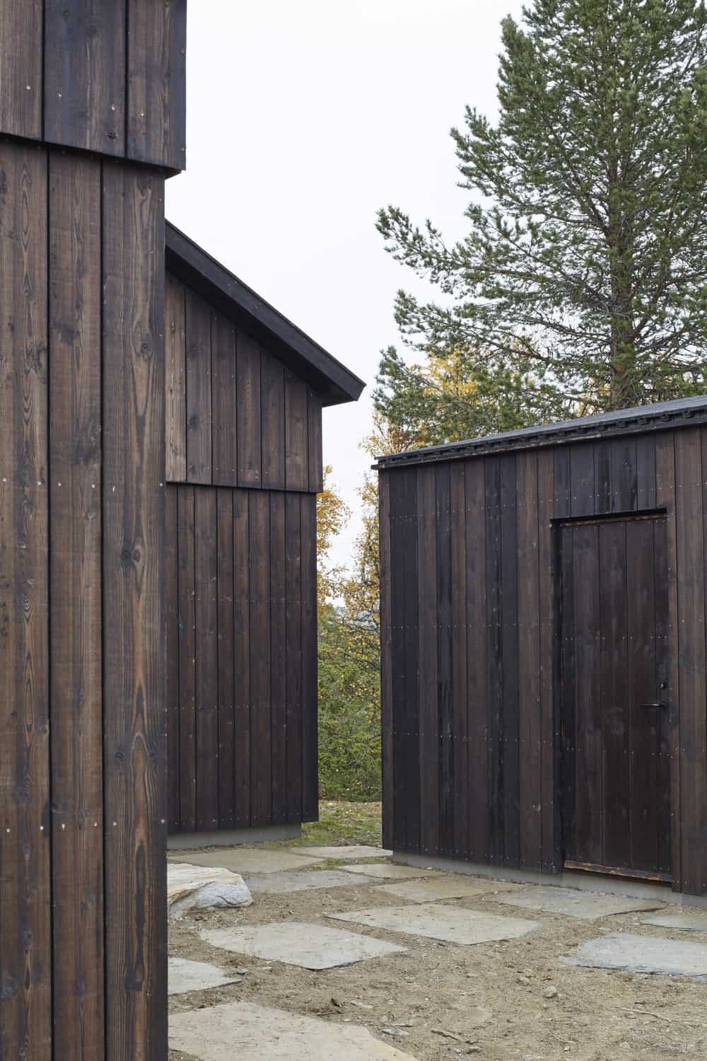 The structures of the house are consistent with its dark wooden tones and design as well as doors that blend with the walls.