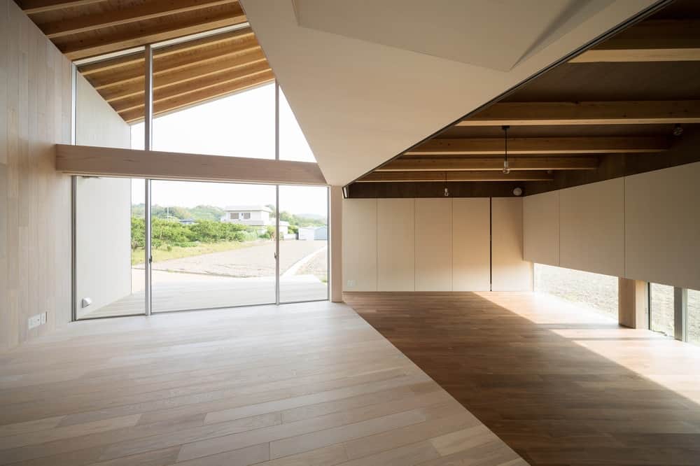 This is a look at the interior of the house with wooden tones on its walls, beamed ceiling and hardwood flooring.