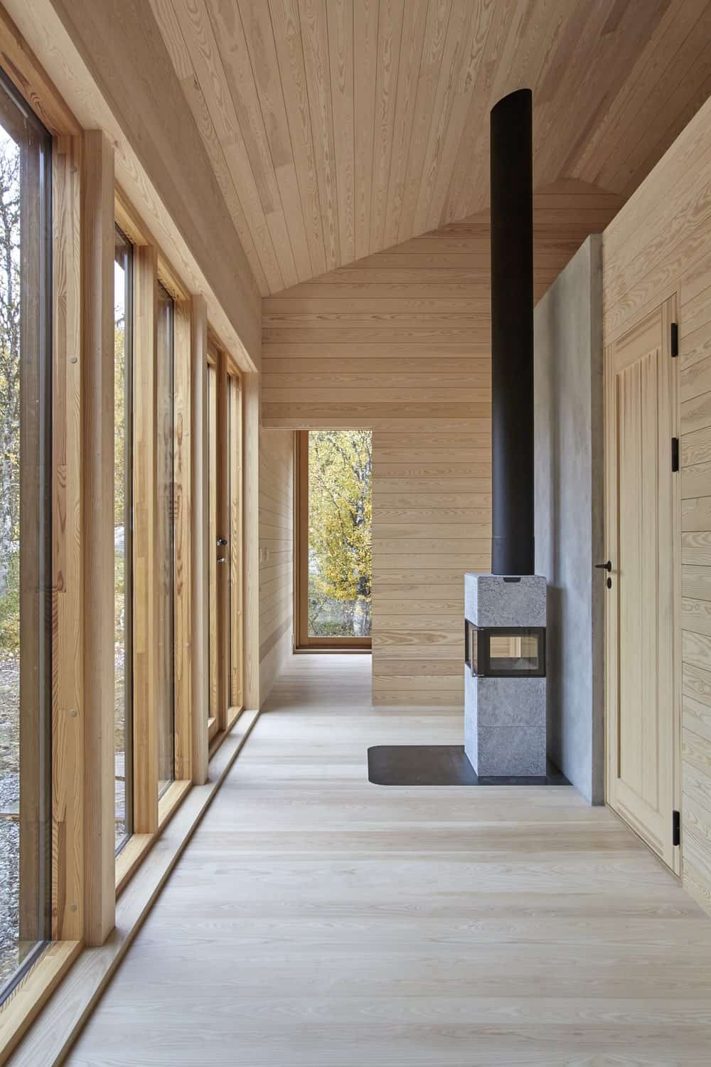Upon entry of the house, you are welcomed by this simple foyer with a warm modern fireplace on the side of the main wooden door.