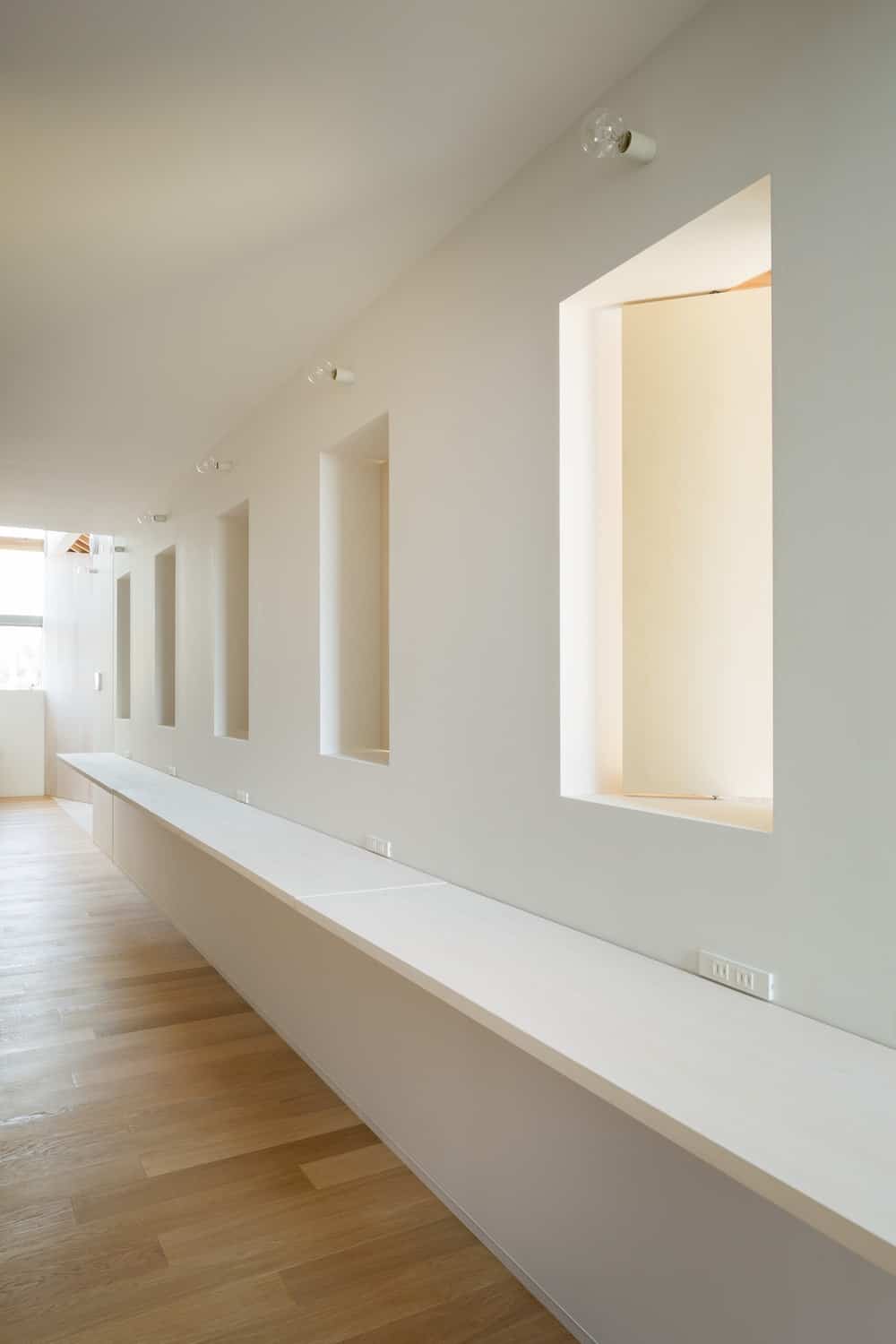 This side of the house has a long floating shelf belong a row of windows that can fit mirrors for a spacious salon. This area has a consistent beige tone illuminated by natural lights.