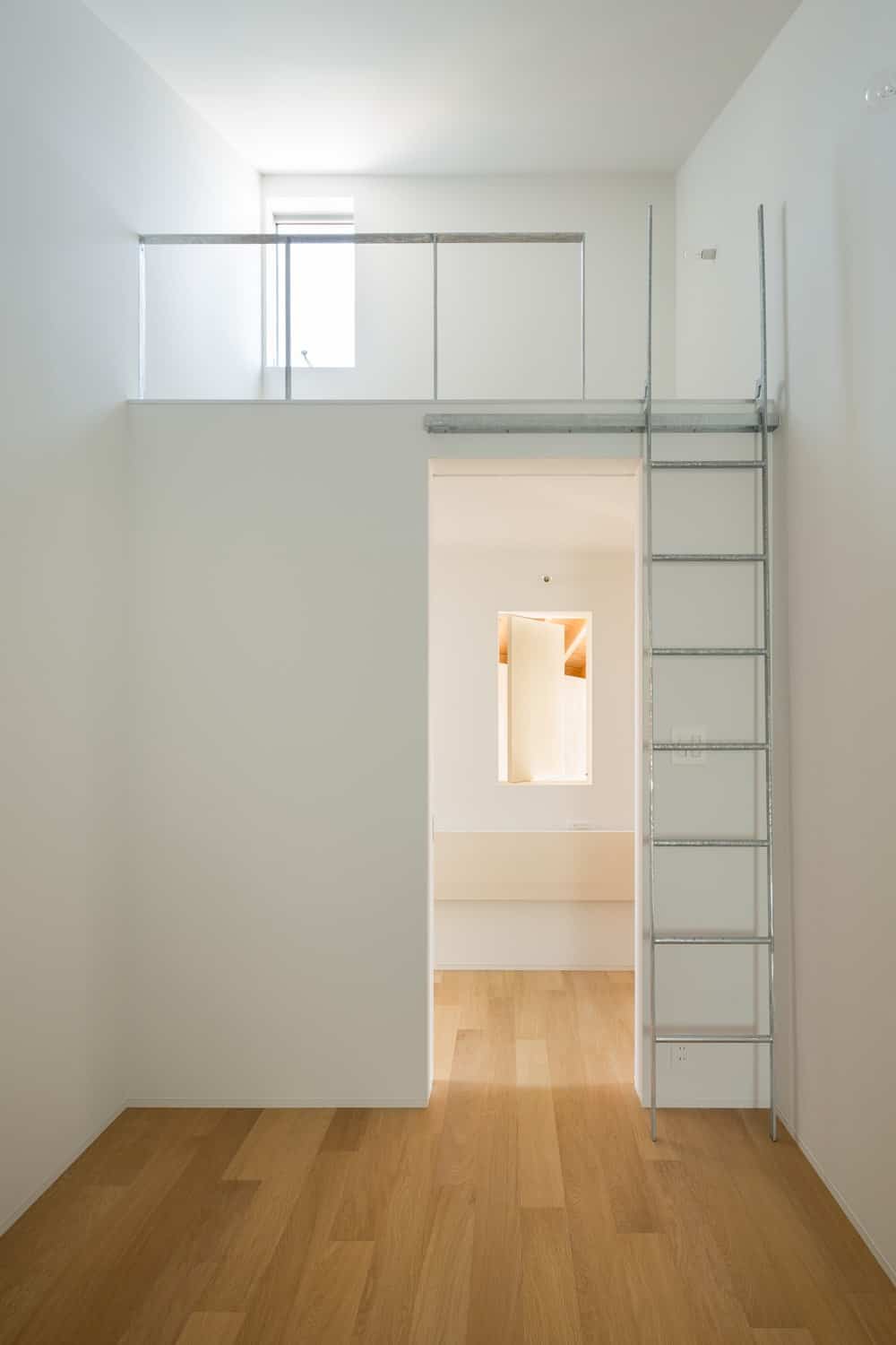 This bedroom has a space above the entryway for the bed that is accessed with a ladder to save space and maximize the vertical area.