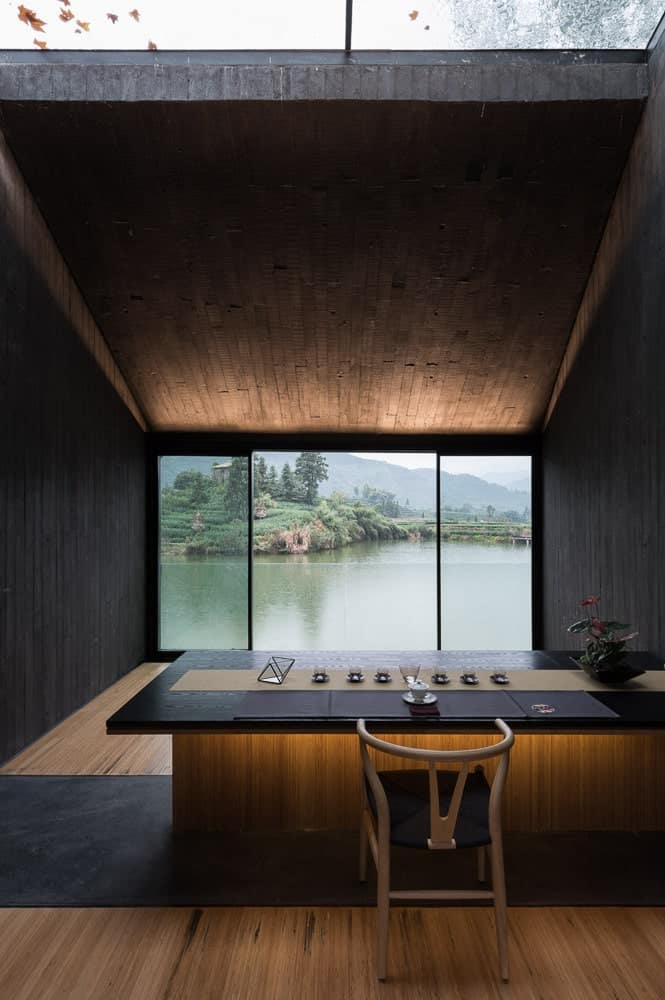 This room has a large glass wall on the far side across from the counter with a view of the water scenery outside.