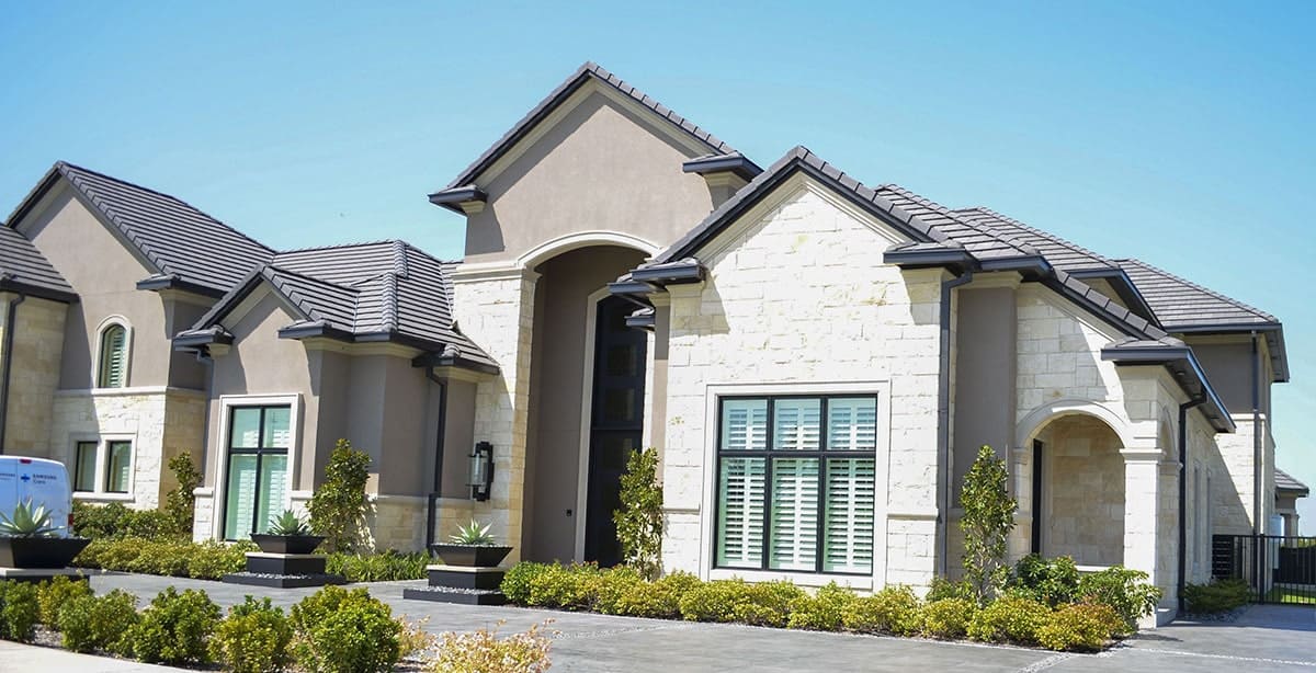 Front exterior view showing the multiple gables, brick cladding, and arched porches.