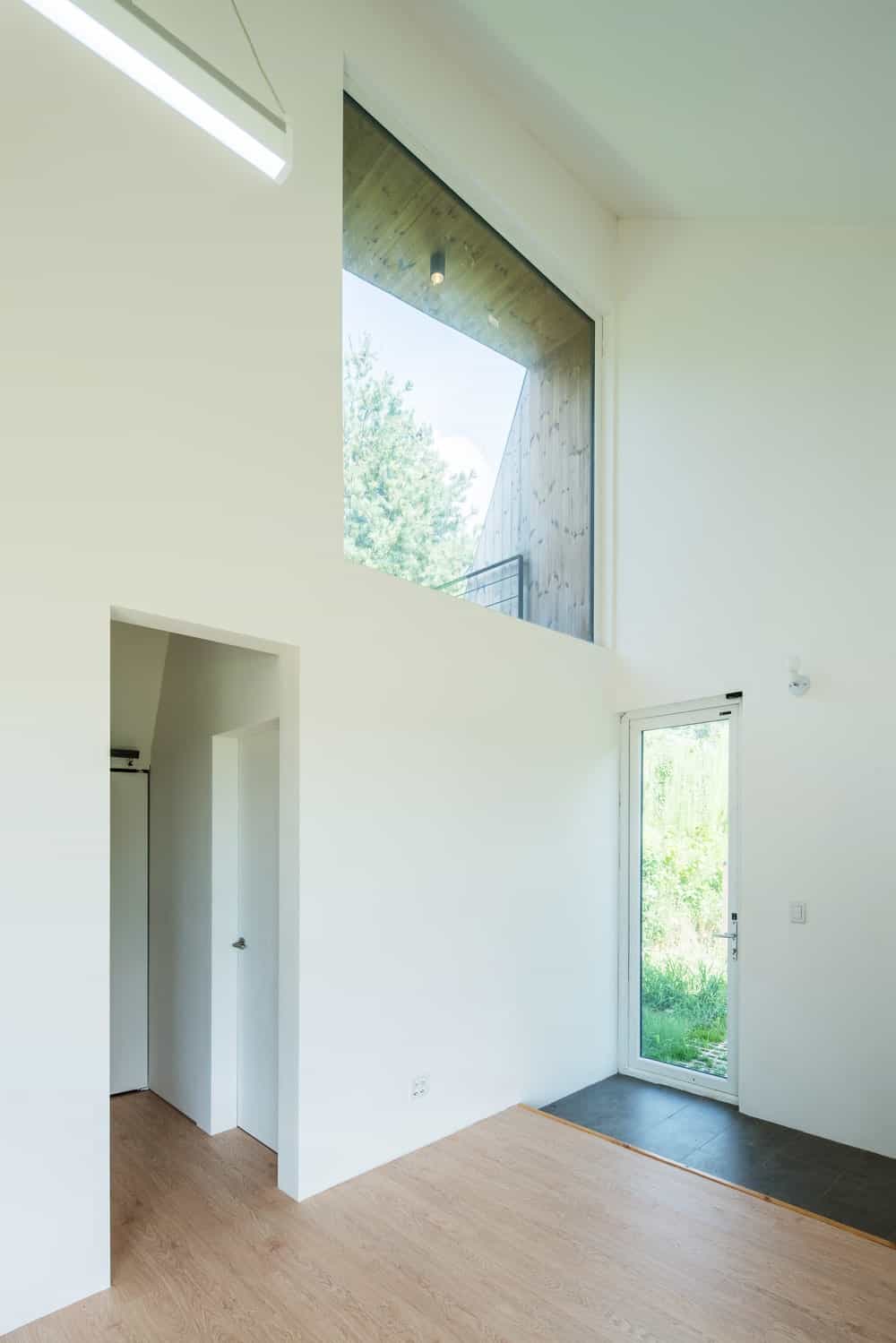 This is a look at the interiors of the house with bright white walls and a soaring ceiling.