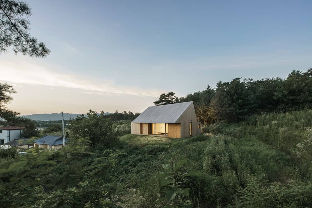 This is a bird's eye view of the house showcasing the warm glow of the house from its glass walls.