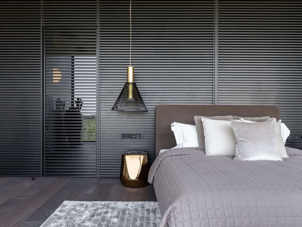 This view of the bedroom showcases the patterned black wall panel behind the headboard.
