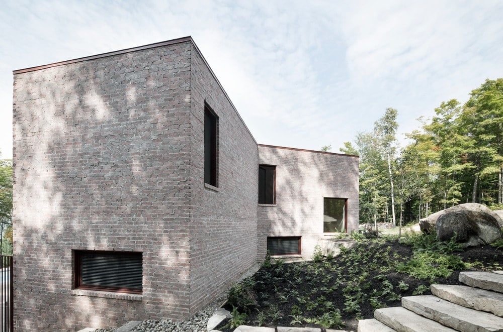 This is a closer look at the side of the house that showcases the brick exterior walls and various windows.