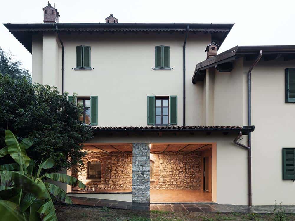 This is a look at the house exterior that has a covered patio area complemented by the adobe walls.