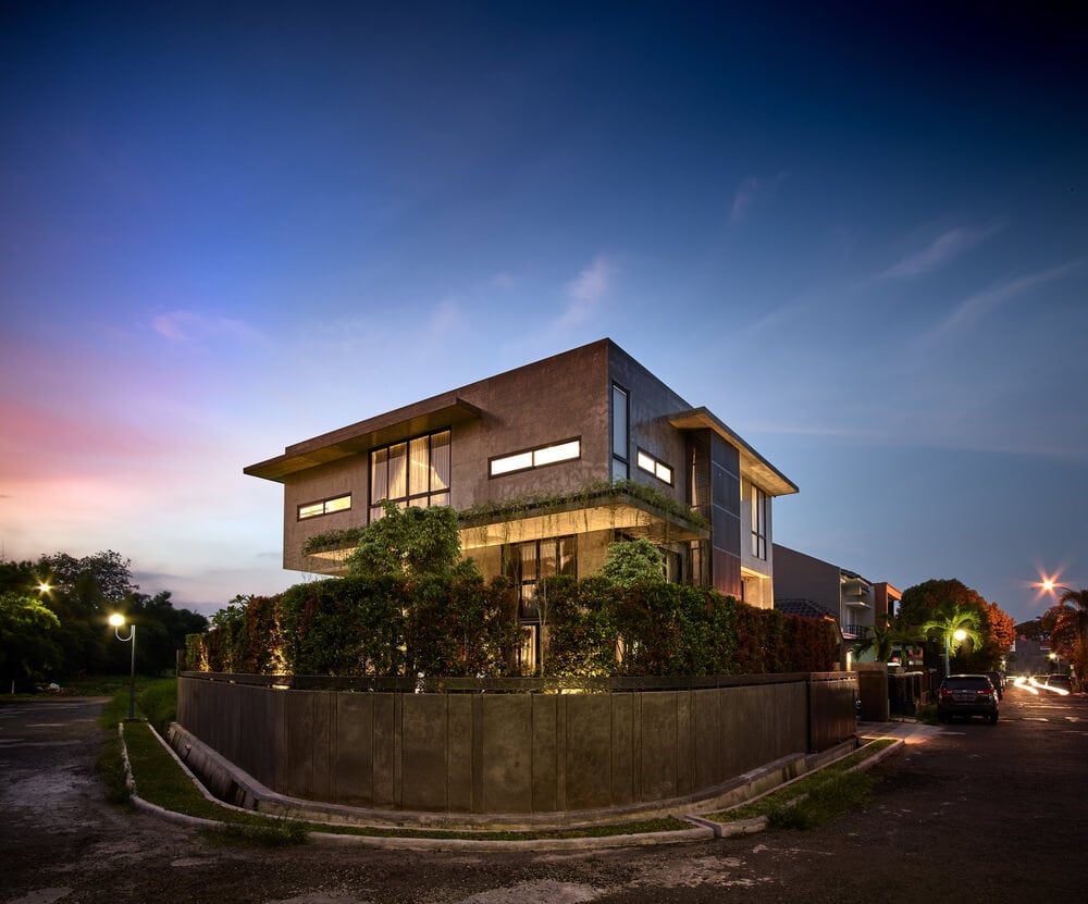This nighttime view of the house showcases the warm glow of the windows and glass walls complementing the concrete exteriors.